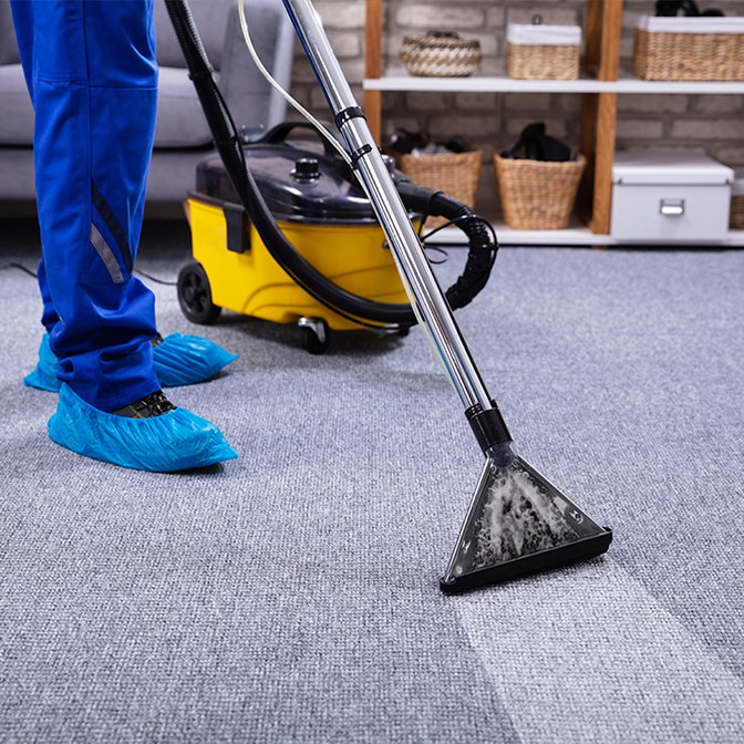 Steritec technician using a deep-extraction machine to clean an office carpet