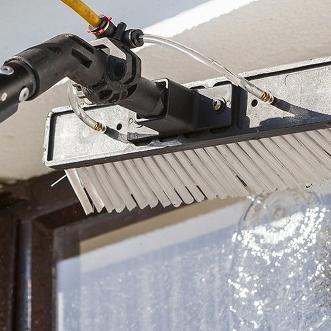 Water-fed pole and brush system cleaning a commercial window